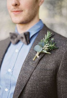 a man in a suit and bow tie with a boutonniere on his lapel