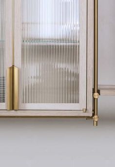 three different views of the inside of a cabinet with glass doors and brass handles on each side