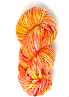 two skeins of orange and yellow yarn on a white surface with the top half turned up