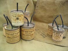 four old fashioned tins with black straws in them sitting on top of a table