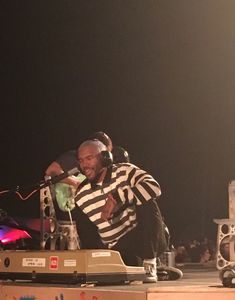 a man sitting on top of a stage with headphones