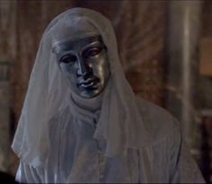 a woman wearing a white veil and black mask