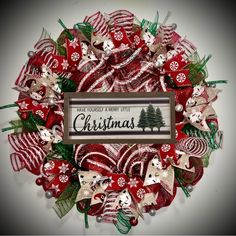 a christmas wreath with red and white ribbons, ornaments and a sign that says it's your merry little christmas