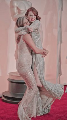 two women hugging each other on the red carpet at an oscars event in los angeles