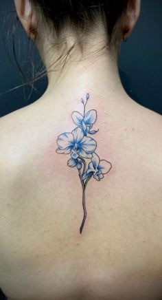 the back of a woman's neck with blue flowers on it