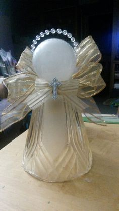 a clear glass vase with a bow on it's head sitting on a table