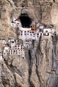 an image of some buildings built into the side of a mountain