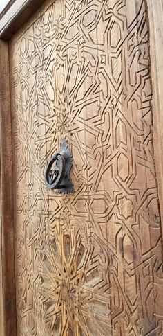 an ornate wooden door with metal handle on it