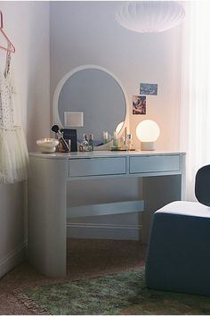 a dressing table with a mirror, stool and lights