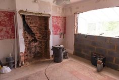 a room that is being remodeled with bricks and paint on the walls, including a ceiling fan