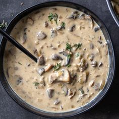 two bowls filled with mushroom soup on top of a table