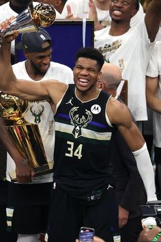 the milwaukee bucks celebrate with their trophy after winning the eastern conference