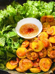 a bowl filled with shrimp next to lettuce and sauce