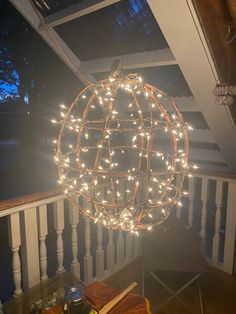 a light ball hanging from the side of a porch