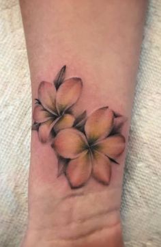 a small wrist tattoo with flowers on it