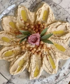 a plate with some food on it and a flower in the middle, sitting on a table