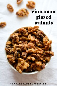 a white bowl filled with candied cinnamon walnuts on top of a white cloth