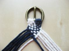 a close up of a pair of scissors on a white surface with blue and white yarn