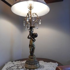 a table with a lamp on top of it and a doily underneath the lamp