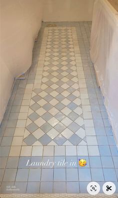 a bathroom floor that has been painted with blue and white tiles, the tile is being cleaned