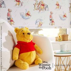 a winnie the pooh stuffed animal sitting on top of a white chair next to a window