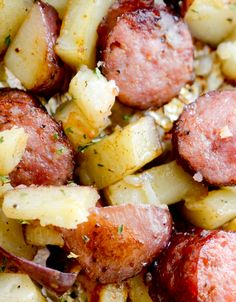 cooked sausage and potatoes on tin foil with seasoning sprinkled on top, ready to be eaten