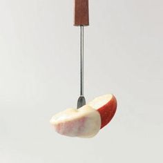 an apple being cut into pieces with a knife sticking out of the top and bottom