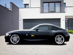 a black sports car parked in front of a house