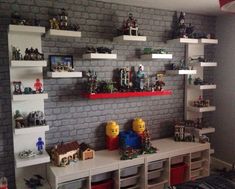 a room with legos on the wall and shelves in front of it that are filled with toys