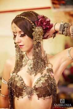 a woman with very large breast wearing gold jewelry and headpieces on her head