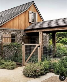 a stone house with a wooden fence around it