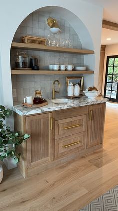 a large kitchen with wooden cabinets and marble counter tops, along with open shelving