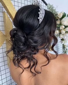 the back of a woman's head wearing a bridal hair comb with flowers in the background