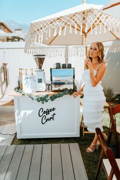 a woman standing in front of a coffee cart