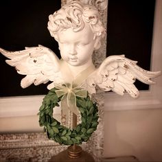 a white statue with wings and a wreath