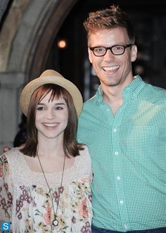 two people standing next to each other smiling