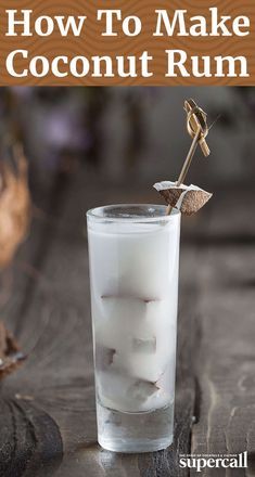 a tall glass filled with ice sitting on top of a table next to a wooden spoon