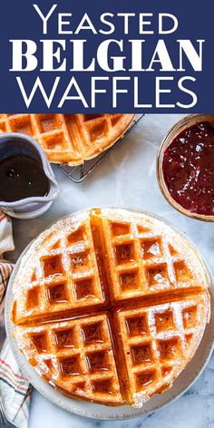 two waffles on a plate with syrup and condiments in the background