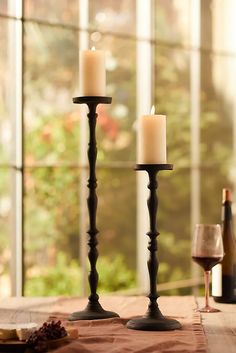 two candles sitting on top of a wooden table