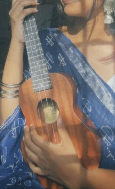 a woman holding a ukulele in her hands