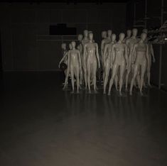 a group of mannequins are standing in a dark room