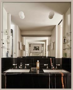 a bathroom with two sinks and mirrors in it