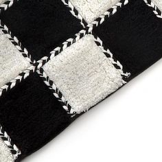 a black and white checkered rug on a white surface