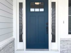 a blue front door with two sidelights on the top and bottom windows above it