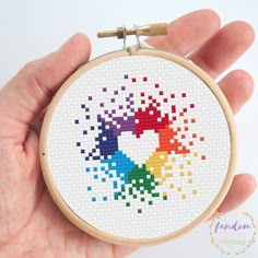 a hand is holding a cross stitch pattern