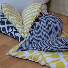 three pillows stacked on top of each other in front of a pillow with an abstract design