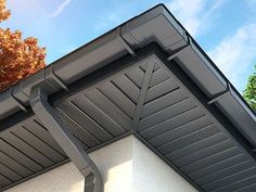 a close up view of the gutter on a house with trees in the background