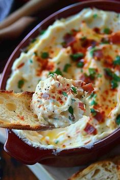 a red bowl filled with cheese and bacon dip