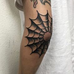 a spider web tattoo on the arm