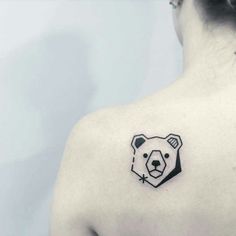 a woman with a bear tattoo on her upper back shoulder and chest, looking at the camera